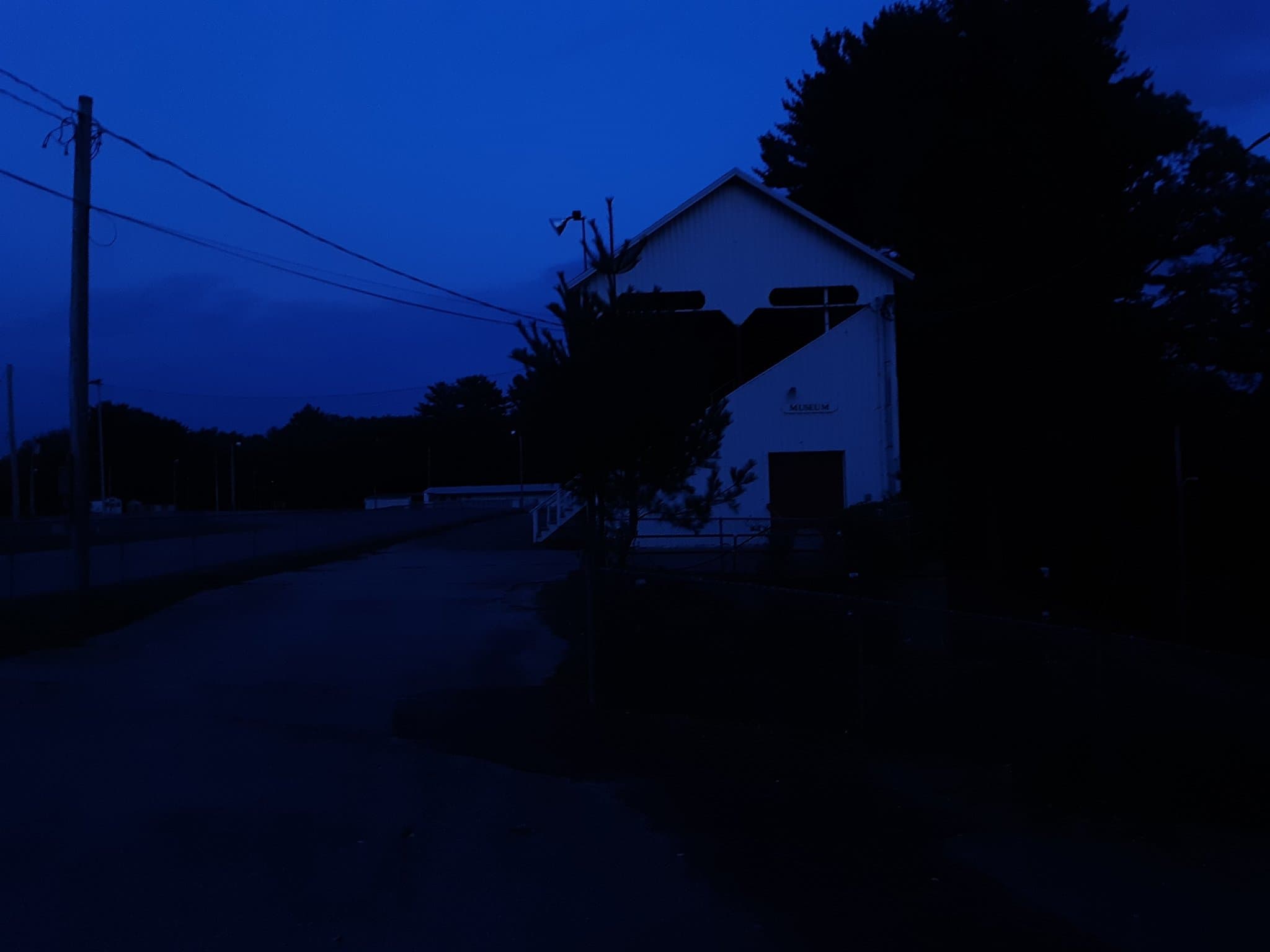Image of a white building labeled \'museum\' at dusk.